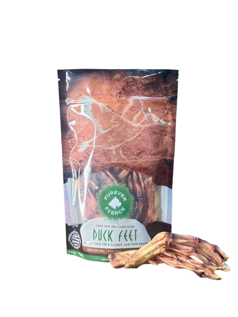 Bag of Forever Paws duck feet treats on a stone surface with greenery in the background