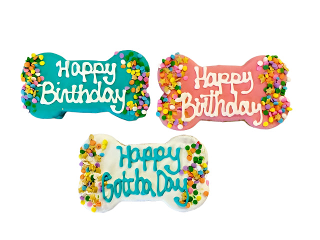 Three colorful bone-shaped birthday cookies with 'Happy Birthday' text on a light gray background.