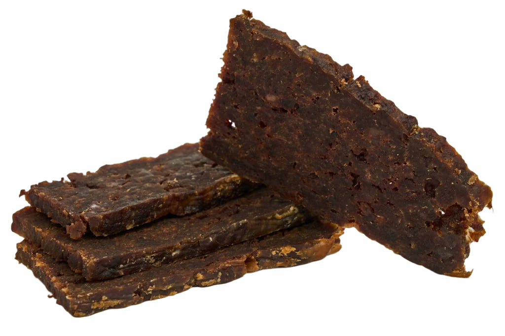 Three dark brown pet treats on a light gray background